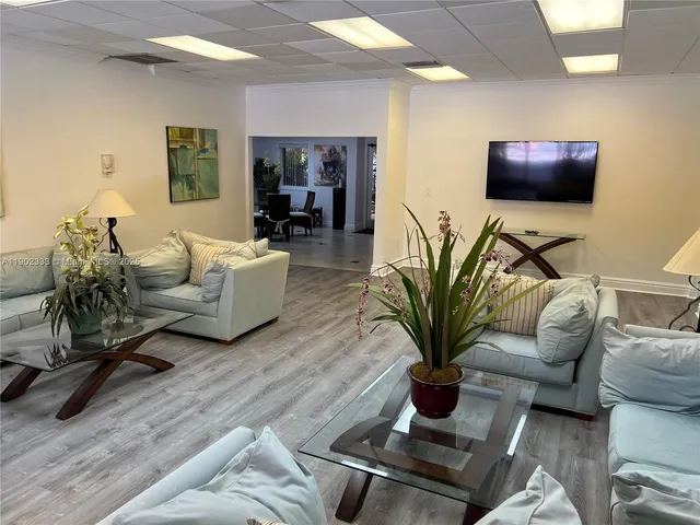 a living room with furniture potted plant and a flat screen tv