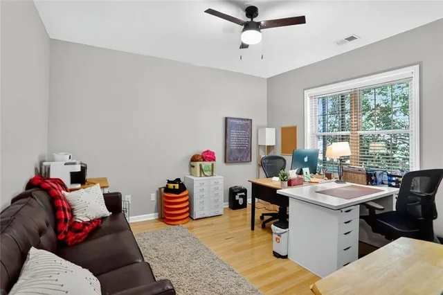 a view of a workspace with furniture and a window
