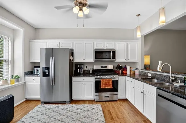 a kitchen with stainless steel appliances granite countertop a refrigerator stove microwave and sink