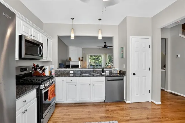 a kitchen with a sink stove top oven and refrigerator