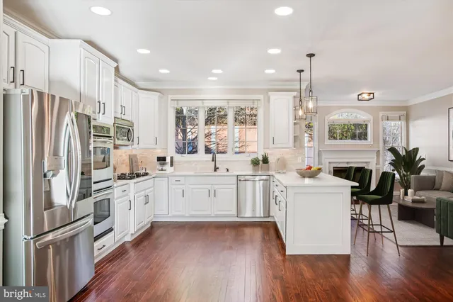 a kitchen with a sink stove cabinets and wooden floor
