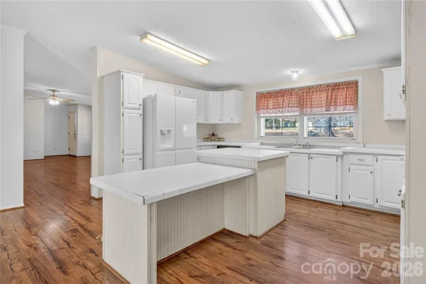 a kitchen with a sink cabinets stainless steel appliances and windows