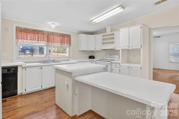a kitchen with a sink window and cabinets