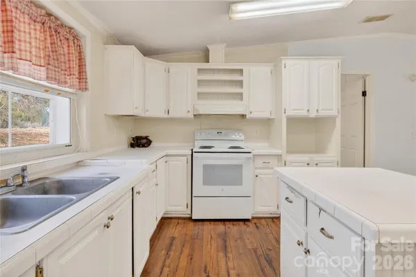 a kitchen with cabinets appliances a sink and a window