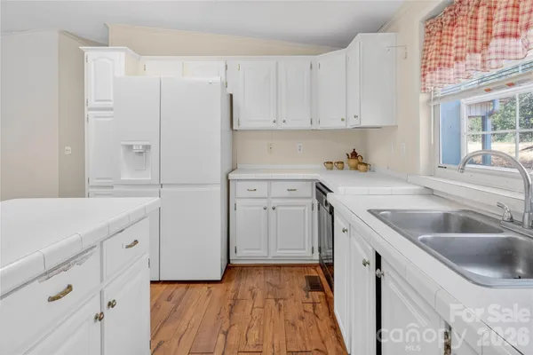 a kitchen with white cabinets and sink