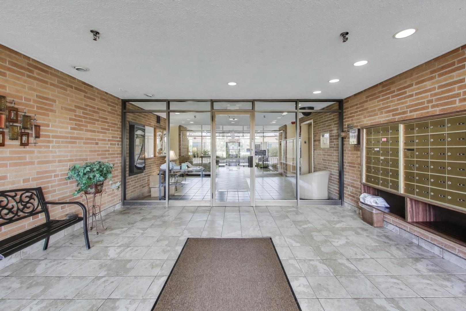 1717 West Crystal Lane, Unit 610 Mount Prospect, IL 60056 - Photo 3 of 23 a large white room with large mirror and furniture