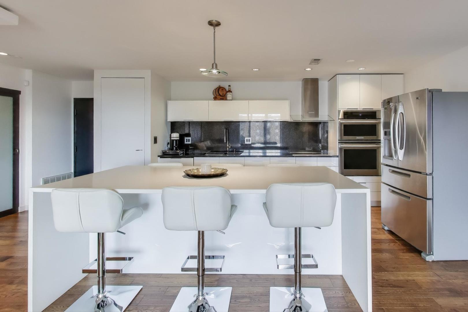 1717 West Crystal Lane, Unit 610 Mount Prospect, IL 60056 - Photo 8 of 23 a kitchen with stainless steel appliances kitchen island granite countertop a refrigerator and a stove top oven