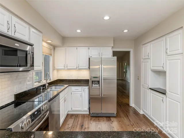 a kitchen with granite countertop a refrigerator stove and microwave