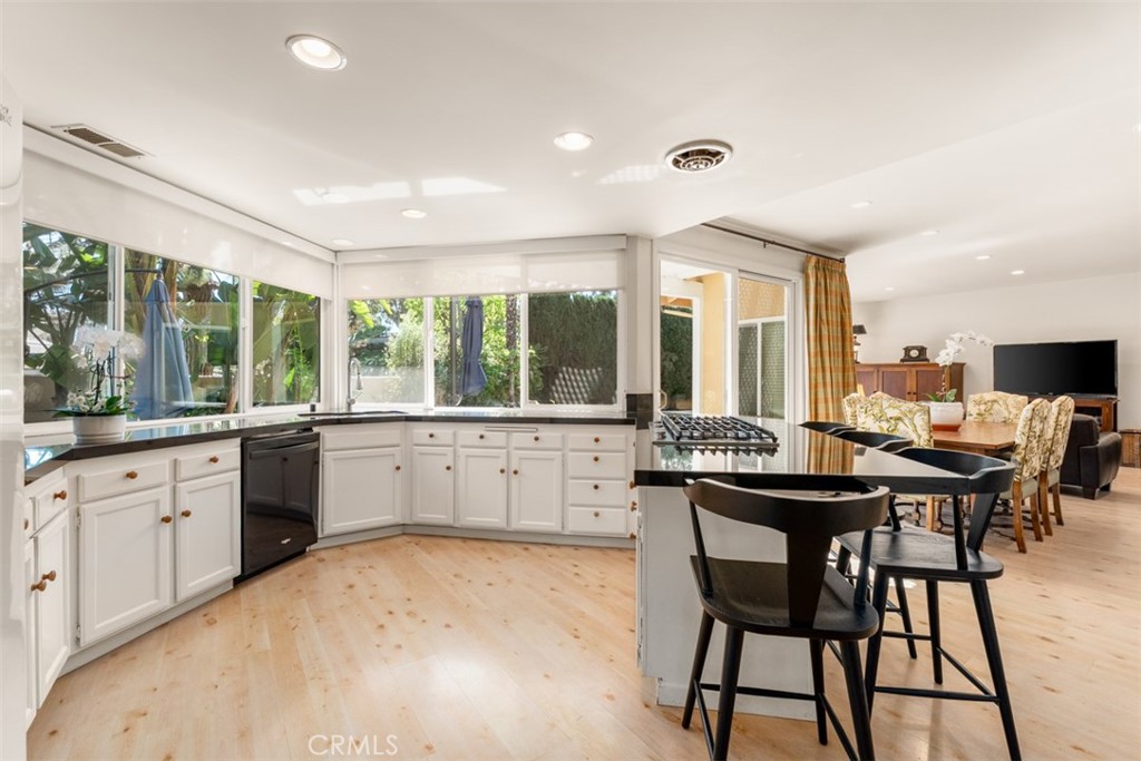 10 Rue Valbonne Newport Beach, CA 92660 - Photo 19 of 66 a kitchen with a stove a sink and white cabinets with wooden floor