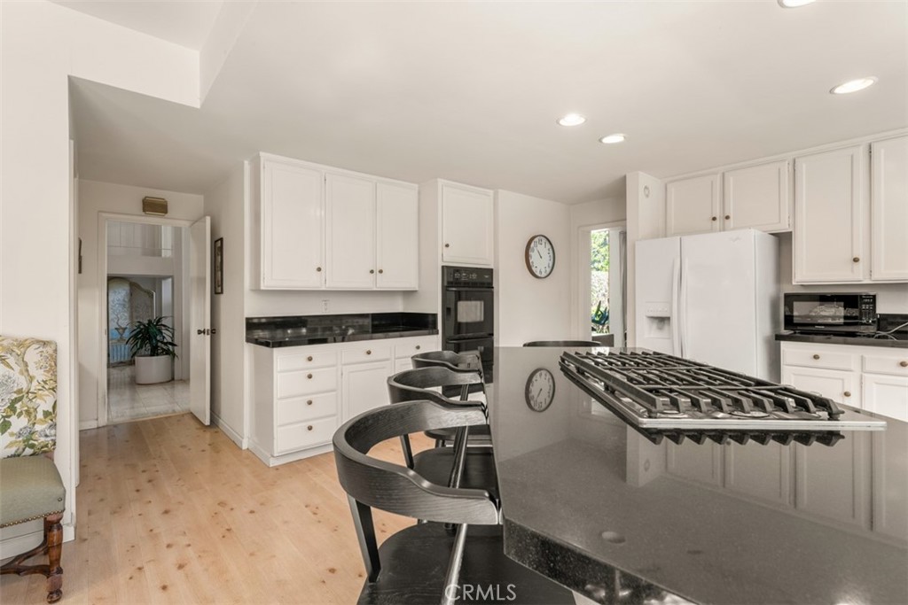 10 Rue Valbonne Newport Beach, CA 92660 - Photo 22 of 66 a kitchen with a refrigerator a stove a sink dishwasher and white cabinets with wooden floor