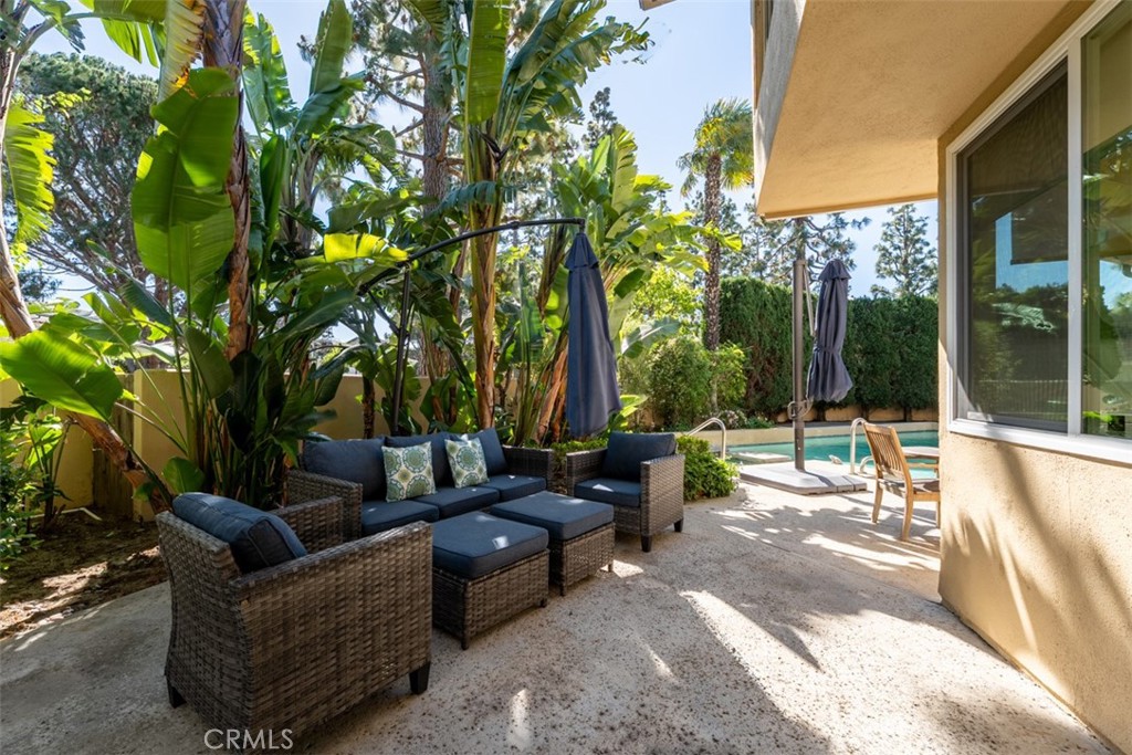 10 Rue Valbonne Newport Beach, CA 92660 - Photo 50 of 66 a view of a patio with couches and table and chairs and floor to ceiling window and tree