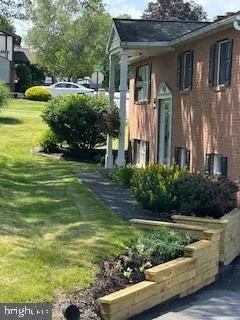 a view of a house with backyard and a tree
