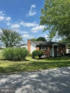 a front view of house with yard and green space