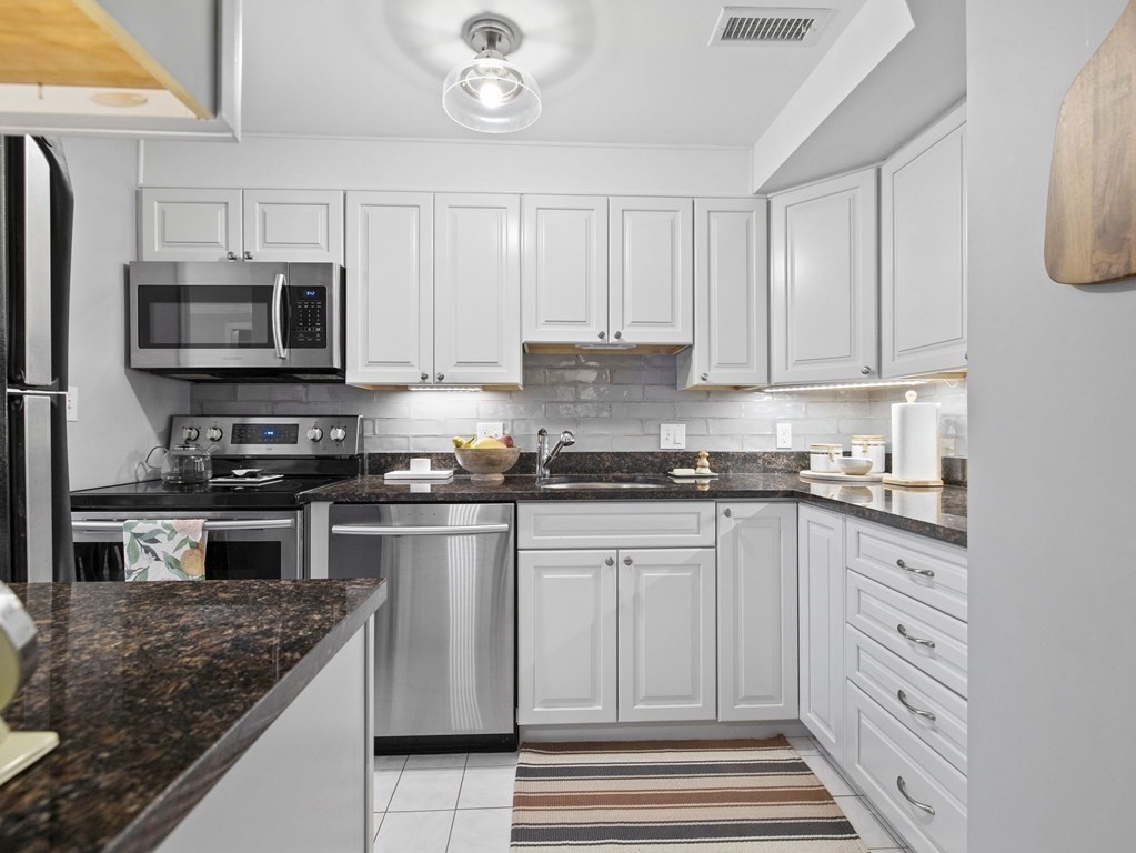 14 Jericho Road, Unit 14 Weston, MA 02493 - Photo 4 of 17 a kitchen with granite countertop white cabinets stainless steel appliances and a sink
