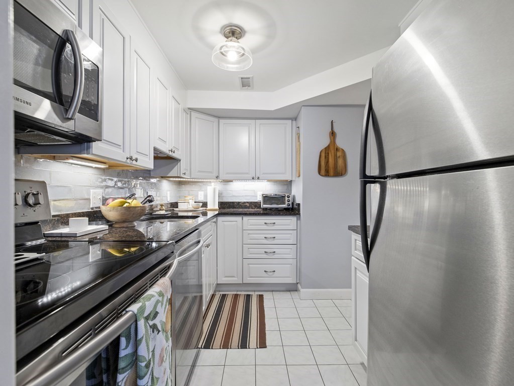 14 Jericho Road, Unit 14 Weston, MA 02493 - Photo 5 of 17 a kitchen with stainless steel appliances a refrigerator sink and microwave