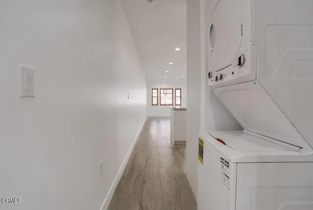 a hallway with white cabinets and wooden floor