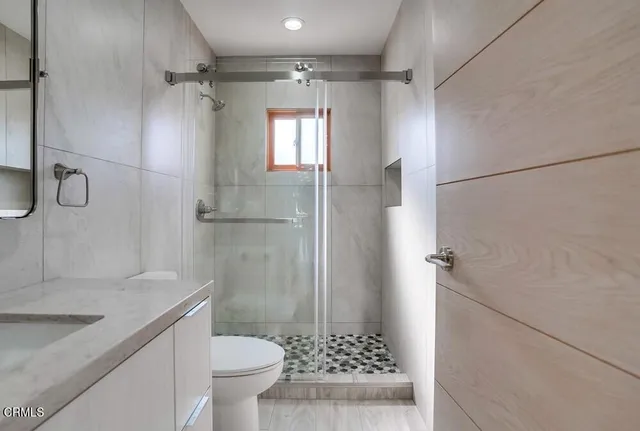 a bathroom with a granite countertop sink toilet and shower