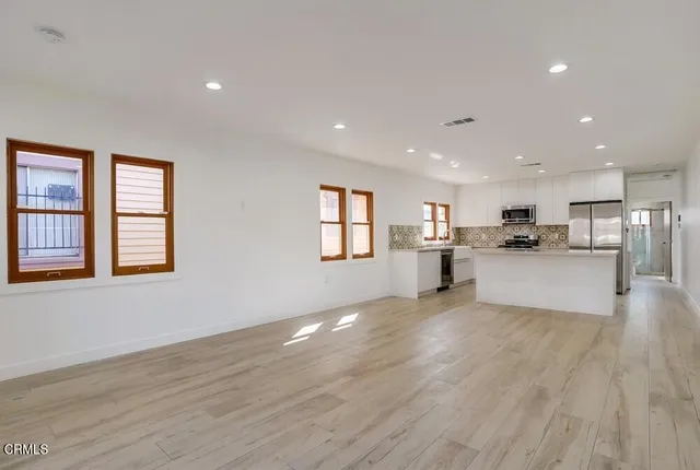 a view of large kitchen with wooden floor and windows