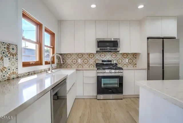 a kitchen with stainless steel appliances a stove sink microwave and cabinets