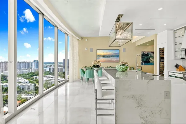 a kitchen with stainless steel appliances kitchen island granite countertop a table and chairs in it