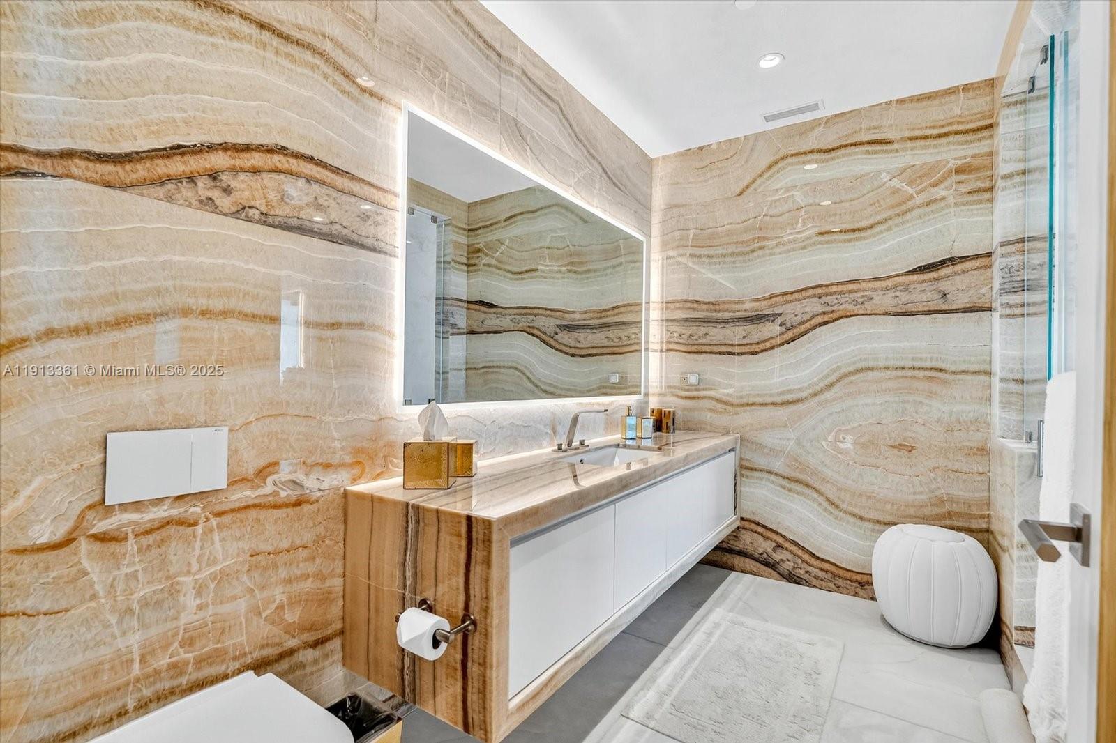 17901 Collins Avenue, Unit 2004 Sunny Isles Beach, FL 33160 - Photo 34 of 55 a bathroom with a sink and mirror with bathtub