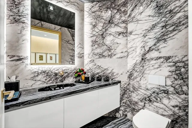 a bathroom with a granite countertop sink toilet a large mirror and shower