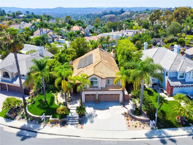 an aerial view of a house with a garden and mountain view