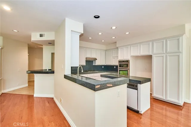 a view of an empty room with chandelier fan and a window