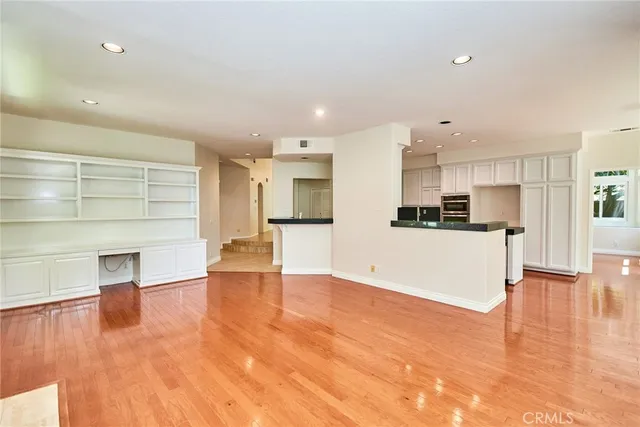 an empty room with windows and fireplace