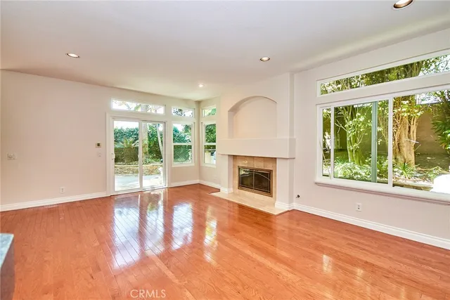 a view of a hallway with wooden floor and a bathroom