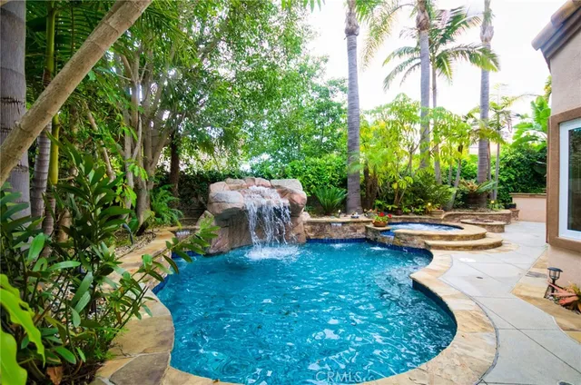 a view of a swimming pool with lawn chairs under an umbrella