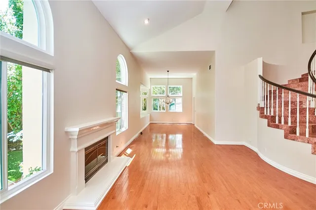 a view of a living room with wooden floor and a fireplace