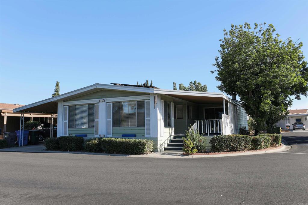 9255 North Magnolia Avenue, Unit SPC 128 Santee, CA 92071 - Photo 1 of 10 a front view of a house with a yard and trees