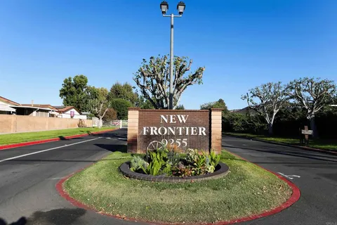 a sign board with a play ground in the back