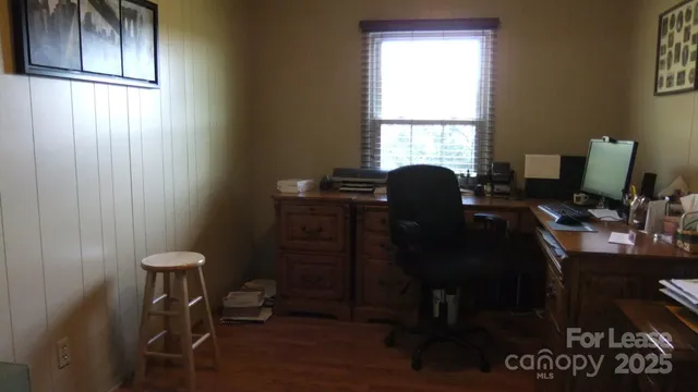 a view of a workspace with furniture and a window