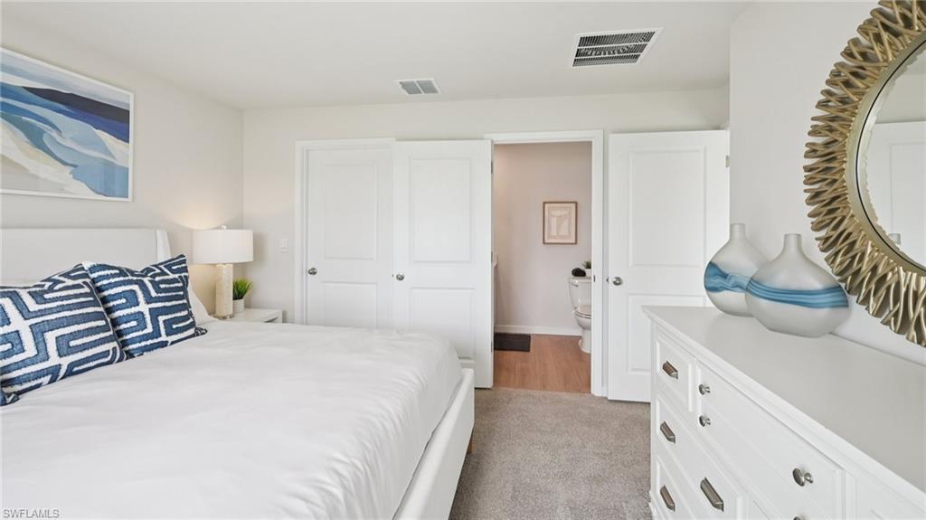 5007 3rd Street West Lehigh Acres, FL 33971 - Photo 11 of 24 Model Home. The bedroom features light-colored walls and carpeted flooring