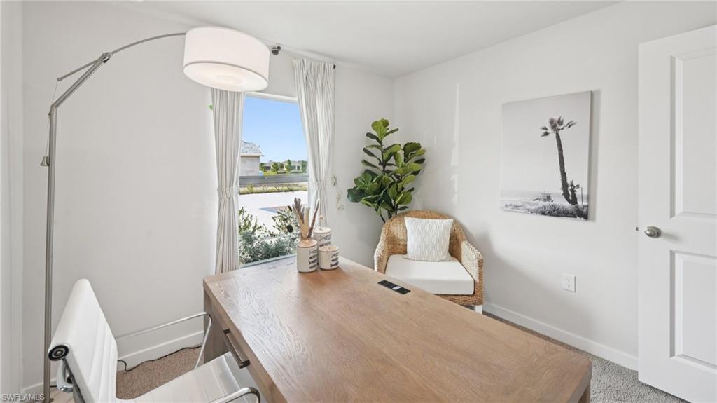 5007 3rd Street West Lehigh Acres, FL 33971 - Photo 17 of 24 Model Home. This room features a window with white curtains, a light wood-toned desk, and white walls