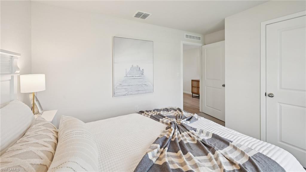 5007 3rd Street West Lehigh Acres, FL 33971 - Photo 20 of 24 Model Home. Bright interior space featuring light-colored walls, a white door with a circular handle, and light-colored flooring visible in the background