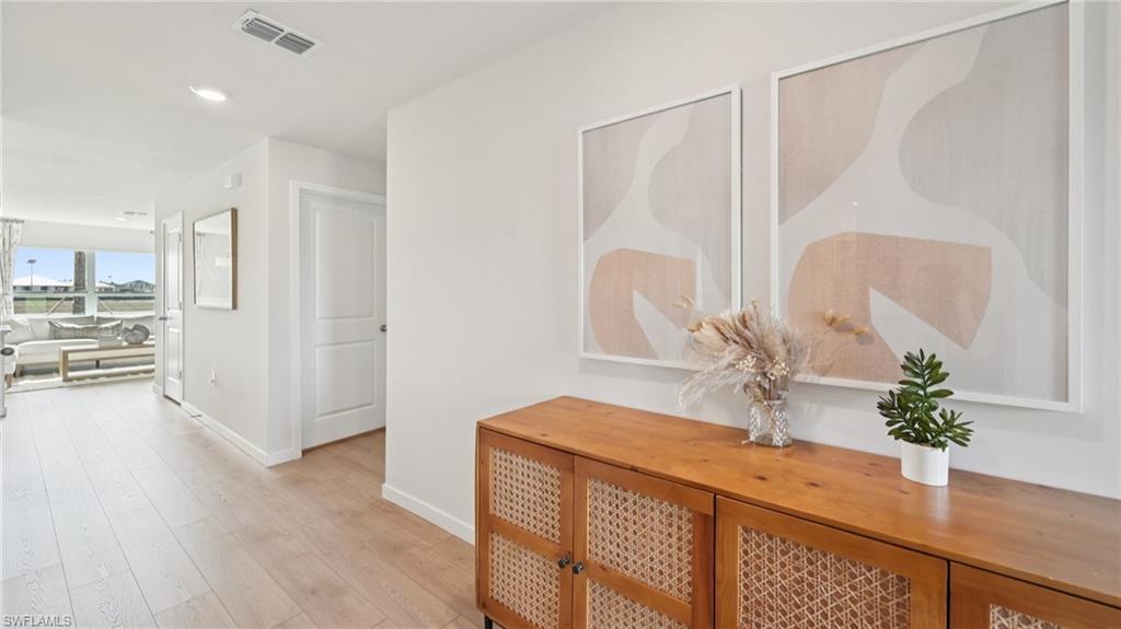 5007 3rd Street West Lehigh Acres, FL 33971 - Photo 10 of 24 Model Home. The property features light-colored flooring throughout the entry area, leading to an open living space with expansive windows