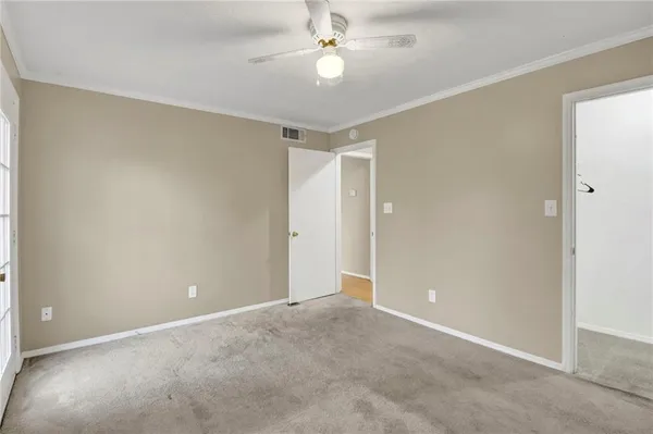 an empty room with closet and a chandelier fan