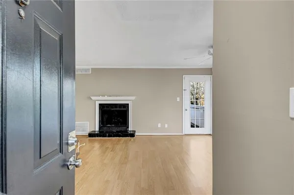 a view of an empty room with a fireplace and a window