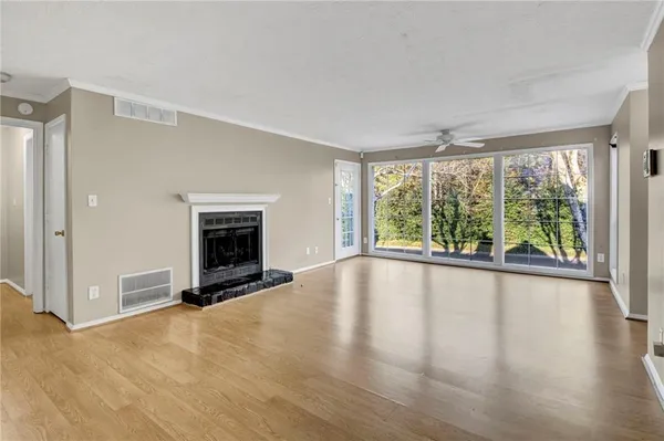a view of an empty room with a window and a fireplace
