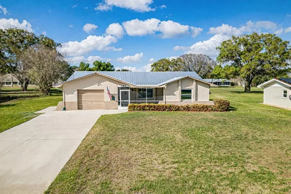 a house with green field in front of it