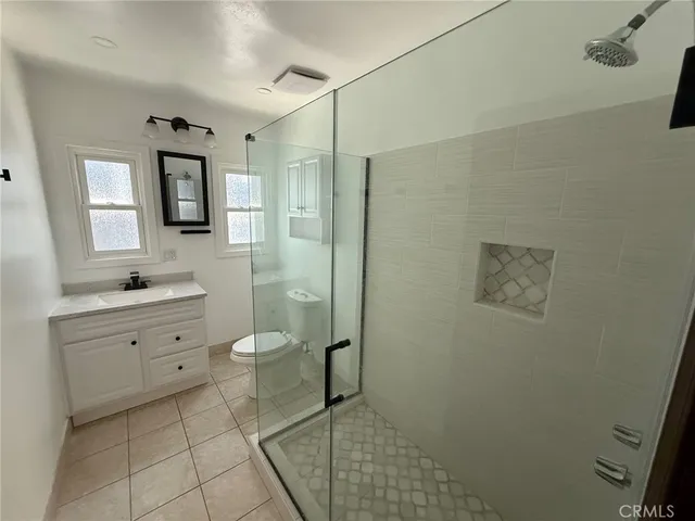 a spacious bathroom with a toilet sink shower and mirror
