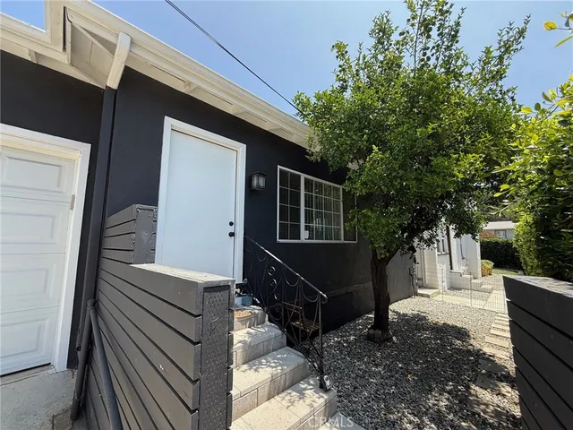a view of a house with a tree beside it