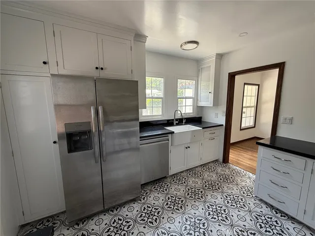 a kitchen with granite countertop white cabinets and stainless steel appliances