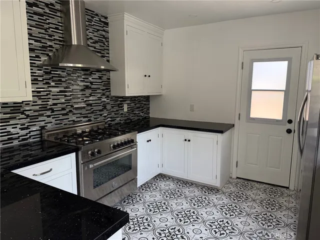 a kitchen with granite countertop a stove a sink and a microwave