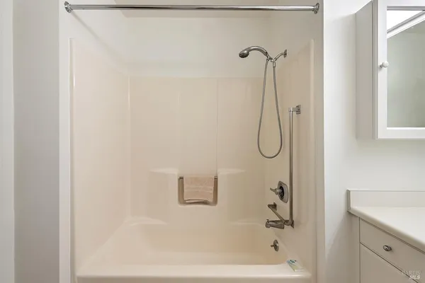 a bathroom with a bath tub with a shower