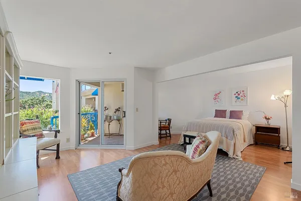 a spacious bedroom with a bed and wooden floor