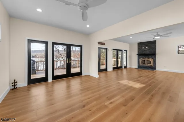 an empty room with wooden floor and a fireplace